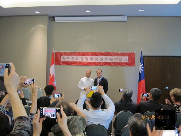 吳新興(左)頒贈海華榮譽章予僑務委員柯江忠(右)