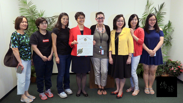 白越珠手持由馬里蘭州州長勞倫斯‧何根簽發的聘任狀, 與出席宣誓就職儀式的親友﹑公司員工等合影。