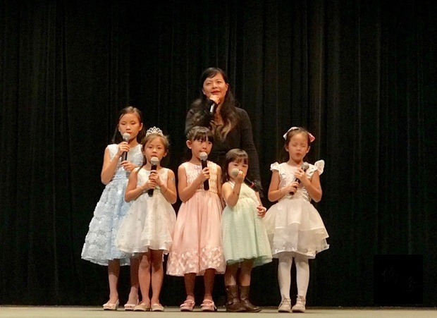 洛麗中文學校家長黃美玲和唱遊班幼童合唱。（世界日報提供）