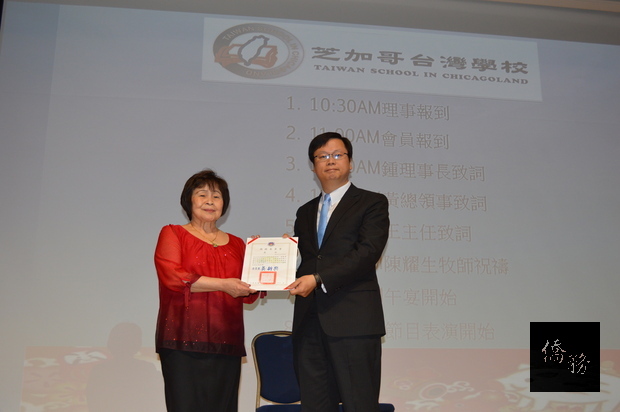 黃鈞耀（右）代表頒發支持響應推動臺灣參與WHA獎狀予臺灣學校，左為鍾美雲。