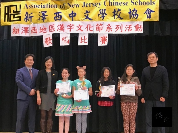 新澤西中文學校協會漢字文化節校際歌唱比賽，中年級雙人組優勝者接受獎盃與貴賓合影，左起：楊文篪、王盈蓉、戴松昌(右一)。