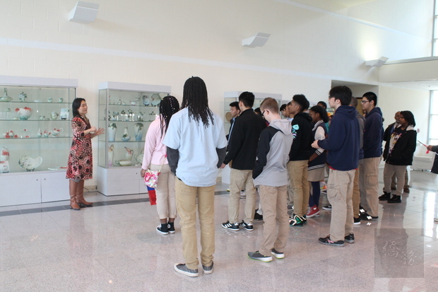 學生們在文化導覽志工蔣宜娟的帶領下參觀中心大廳陳列的法藍瓷。
