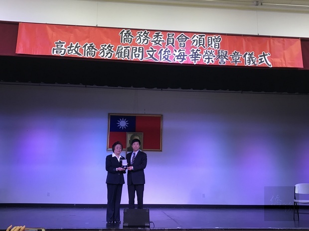 馬鍾麟(右)頒高文俊海華榮譽章,由于愛珍(左)代表接受。