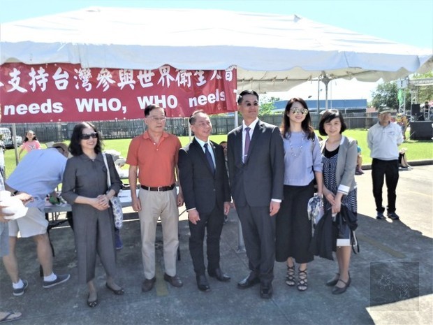 現場也有支持台灣參與世界衛生大會簽名連署攤位，陳家彥（右三）與武修伯（右四）於攤位前合影。（世界日報提供）