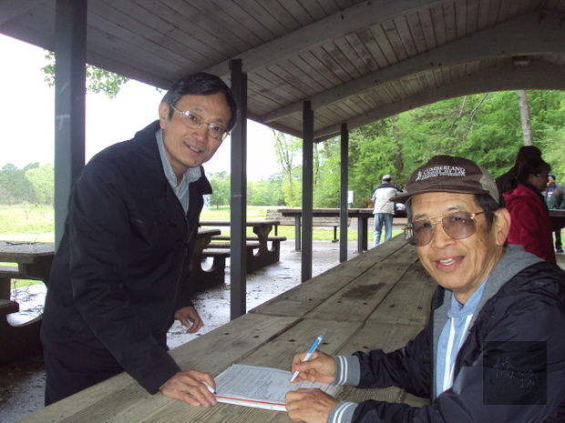 蔡昆峰(左)為鄉親邱同勝提供辦理「僑胞卡」的服務。（世界日報提供）