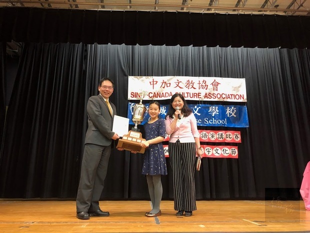 夏基陸(左)頒發國語演講比賽總冠軍將盃給石洛桐(中)。