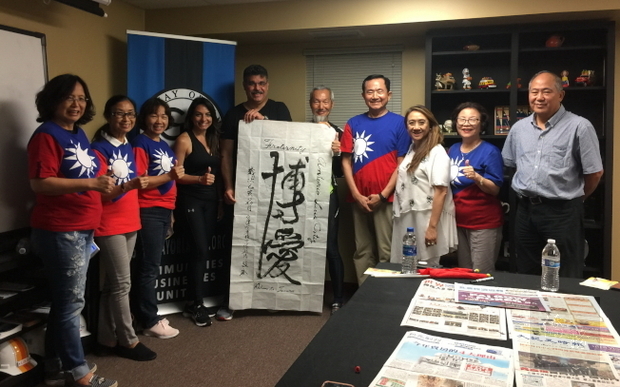 不老騎士陳敏先(右五)以現場揮毫的書法博愛贈送議員奧提茲(左五)。(世界日報提供)