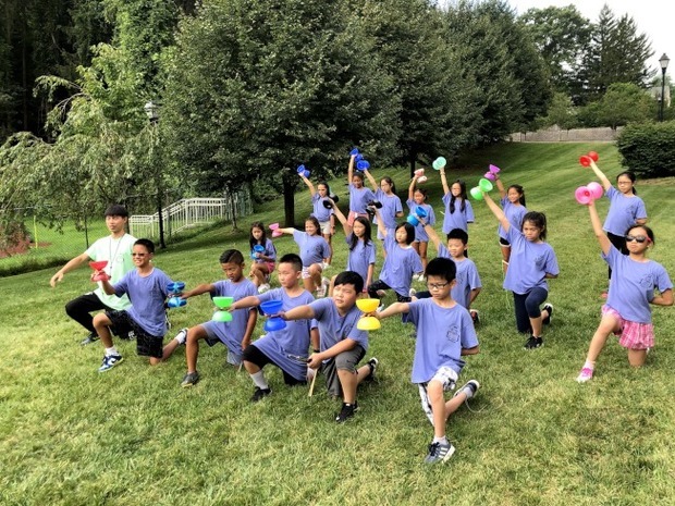 孟郡中文夏令營,蕭鴻偉在室外教扯鈴課。(世界日報提供)