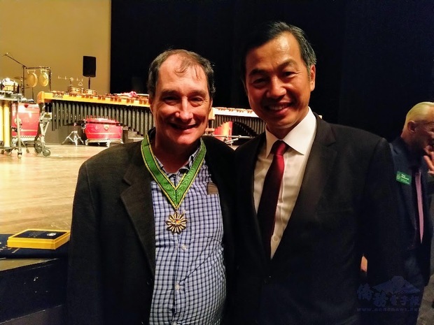 陳剛毅(右)代表僑委會委員長吳新興頒贈Smith總編輯(左)僑民之友榮譽章