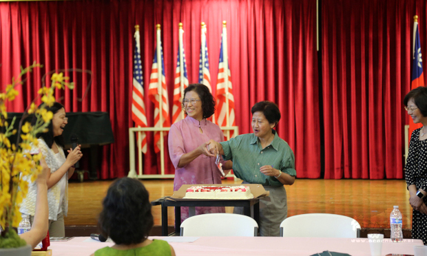 服務滿20年獲頒銀質獎章的老師陳小燕(左二)和蔡仲彥(左三)，歡喜地切蛋糕慶祝教師節。（世界日報提供）