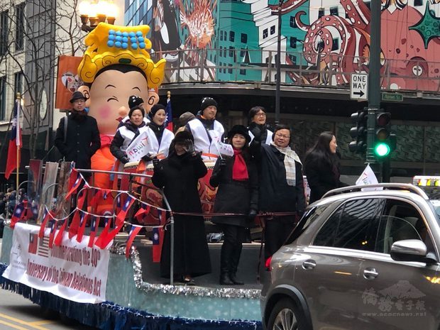 黃鈞耀夫婦(前排右2及右3)於花車上向民眾揮手，花車上懸掛紀念「臺灣關係法」40週年橫幅。