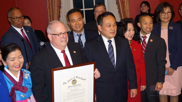 霍根(前左二)和夫人金有美(前左一)一起頒發新年賀狀予亞裔。(王洋提供)