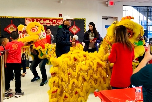 陳家彥和夫人黃惠榆將紅包塞入舞獅口中,寓意萬事大吉。(世界日報提供)