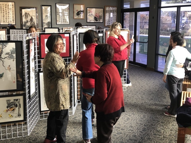 僑胞觀賞字畫。（黃本初提供）