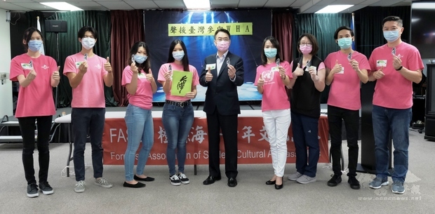 目前新冠肺炎疫情仍肆虐全球，大家手持FASCA橙縣分會青年文化志工楊晨君(左四)設計的臺灣紋身貼紙，為「Taiwan Is Helping」按讚。