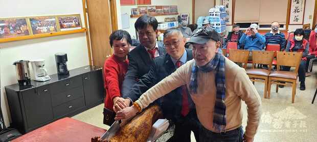 (右起)伍伯和，湯偉立，阮振強，余麗媖等人切金豬，敬告關公。(波士頓洪門致公堂提供)