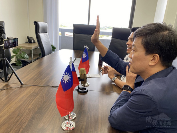 駐關島辦事處處長陳盈連(舉手者)和政治組副參事許書智20日在辦事處參加視訊會議,與美屬北馬里亞納群島總督托瑞斯等人討論與台灣建立旅遊泡泡等議題。(駐關島辦事處提供)