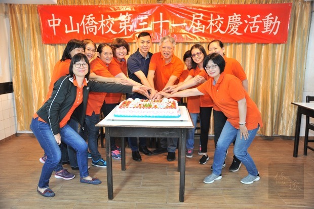僑校校長司徒梓明、僑務秘書廖建勛與全體教師一同代表切蛋糕慶祝僑校31週年。