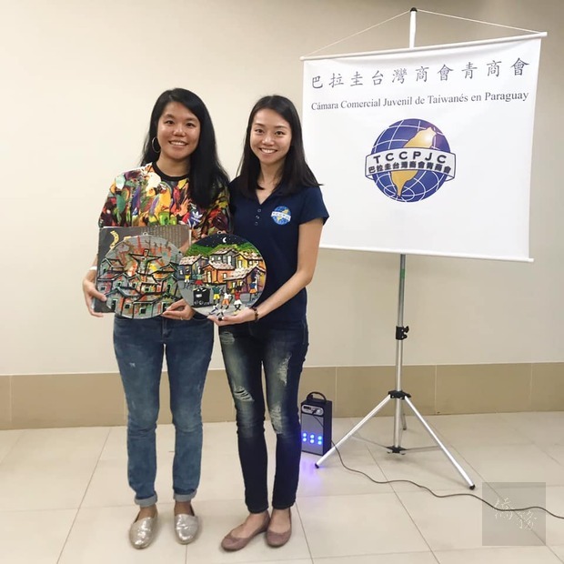約克(左)帶來了她在「大社區」購買的紀念畫作，致贈給青商會，會長劉倩如(右)代表接受。