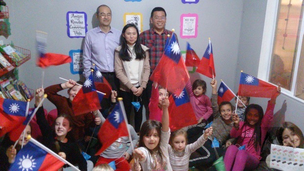 學生們完成作品後，興奮地揮舞中華民國國旗，與(後排右起)詹前校、連晏均、柯俊同合影。