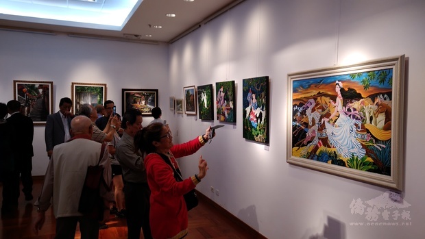 參觀展覽民眾於欣賞畫作之餘不忘拍照留念。