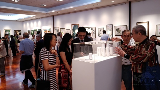 僑務促進委員陳家靖(前排左3)向參觀民眾說明他的陶藝作品創作理念。
