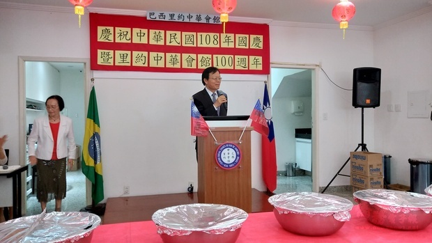 何建功(手持麥克風者)簡介臺灣過去一年來在經濟與國防的成就,並勉勵里約中華會館順利走過下一個百年。