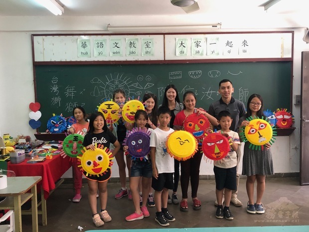 文化志工客座教師陳信汝(後排中)訪中正僑校，開班教授同學們以簡單的素材，製作臺灣獅頭面具。