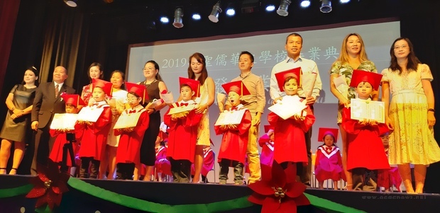 畢業生由家長陪同受頒畢業證書，由林志孟校長(左二)代表頒發。