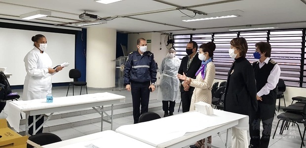 大都會民警局醫䕶人員向徐澤玗（右一）、支黃秀莉（右二）等人介紹檢測流程。