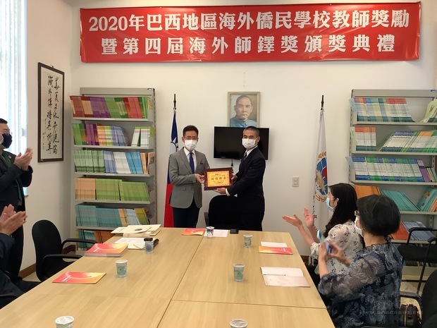 馮光中代表頒發第四屆海外師鐸獎獎座予徐勝鈺(立者右)，鼓勵並肯定他在教育上的付出與奉獻。