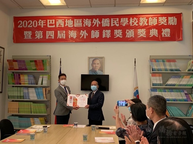 林志孟(立者右)代表聖儒華文學校獲得海外僑民學校教師獎勵的12位教師領獎，接受大家的祝賀。