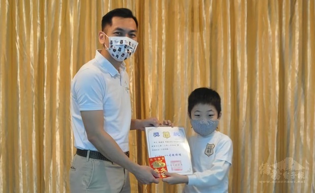 駐巴拉圭大使館僑務秘書廖建勛代表頒發校際硬筆字暨作文比賽獲獎同學獎狀及獎學金。