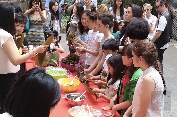 義大利唯一的台灣中文學校8日舉行休業式，現場邀請許多外國親友一起體驗包粽子。（中央社提供）