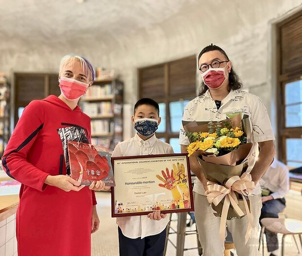 台灣學童藍紹齊（中）參加第48屆捷克利迪策國際兒童美術展（ICEFA Lidice）獲優選，26日在台北接受捷克駐台副代表唐笛（左）頒獎表揚。（Pink Art畫室黃勝彥老師提供） (圖：中央社)