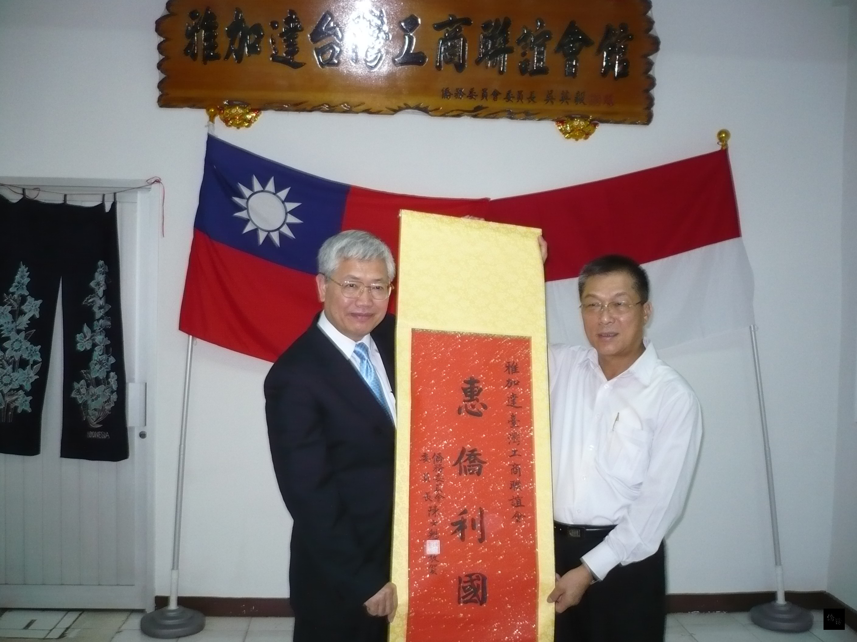 僑委會委員長陳士魁（左）致贈「惠僑利國」掛軸給雅加達台灣工商聯誼會，由理事長邱泳方（右）代表接受。（駐印尼代表處提供）