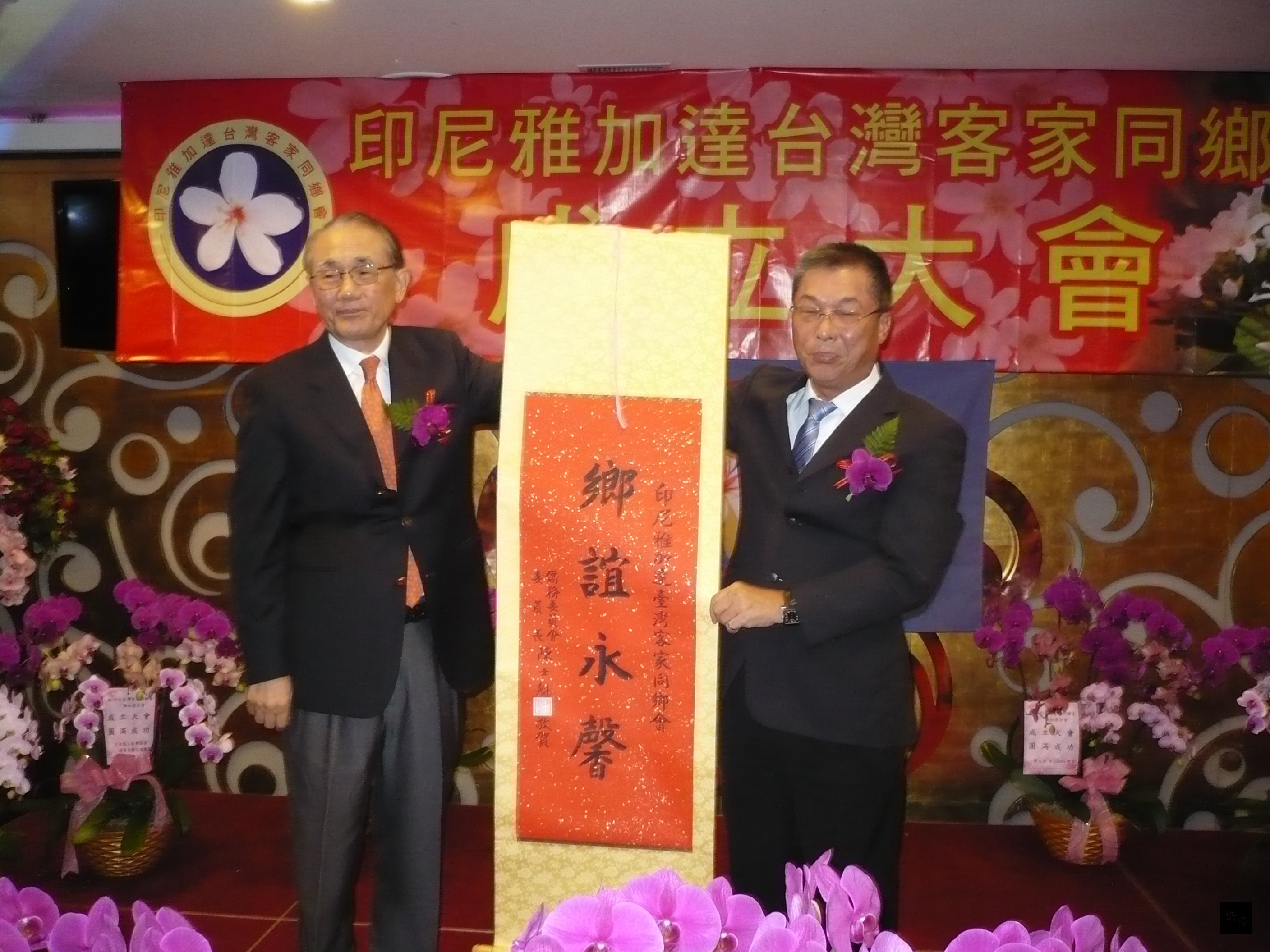 駐印尼代表張良任（左）代表僑務委員會委員長陳士魁致贈「鄉誼永馨」掛軸給印尼雅加達客家同鄉會，由會長邱泳方代表接受。（駐印尼代表處提供）