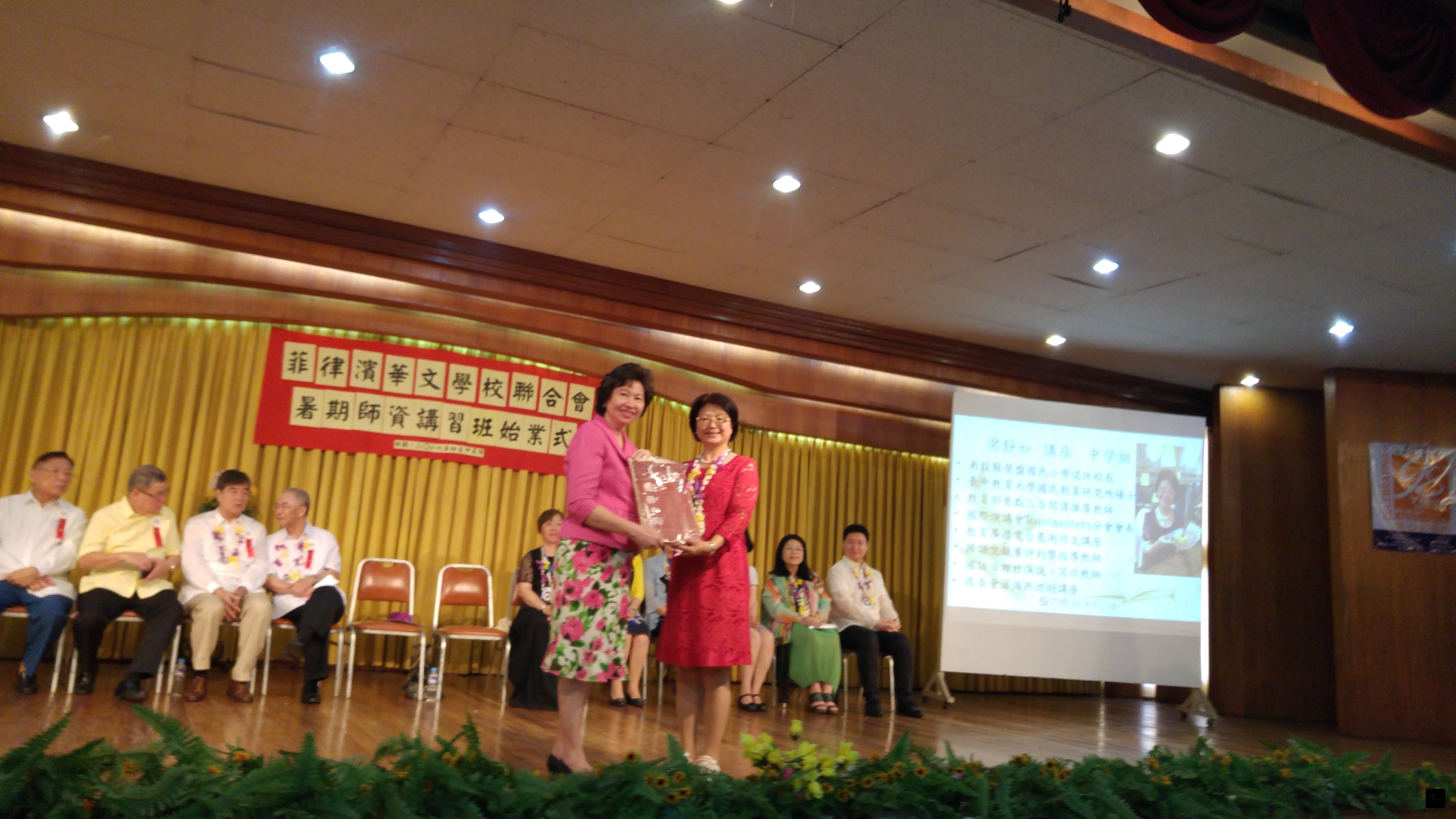 菲律賓華文學校聯合會暑期師資講習班團長梁靜如致贈紀念品給主辦單位聖公會中學校長吳紫薇。(菲華文教中心提供)