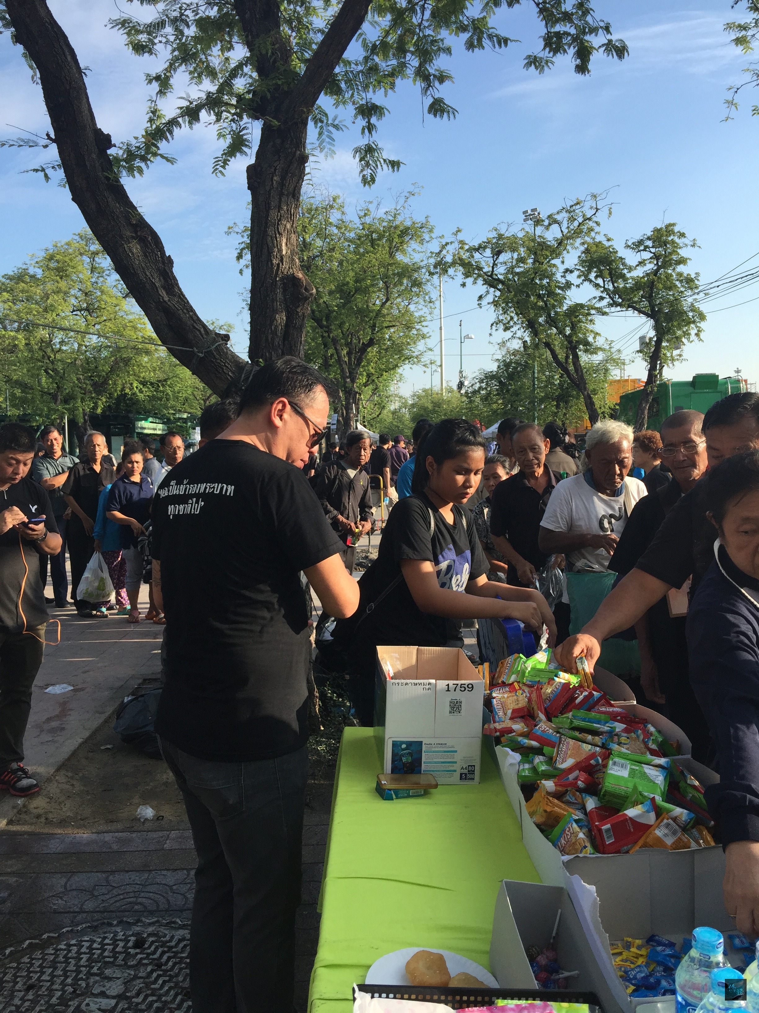 泰王蒲美蓬病逝，大批民眾在大皇宮及皇家田廣場周邊祭拜悼念，泰國拉加邦台商聯誼會發起送物質到皇家田活動，將台商愛心送到曼谷皇家田廣場給現場民眾。（泰華文教中心提供）