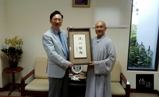 釋常學法師（右）贈送駐泰國代表童振源「滿一個願」題字。（泰華文教中心提供）