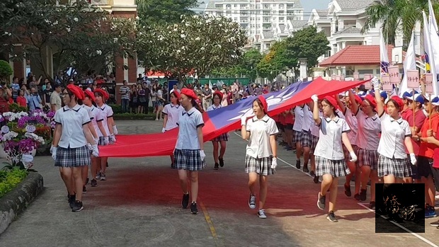 穿著整齊劃一制服的臺校女同學迎國旗進場。