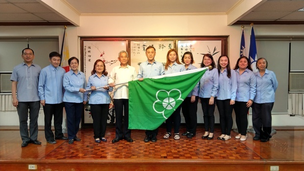 徐佩勇將菲華青年服務團總團部的旗幟轉遞給王家鵬。