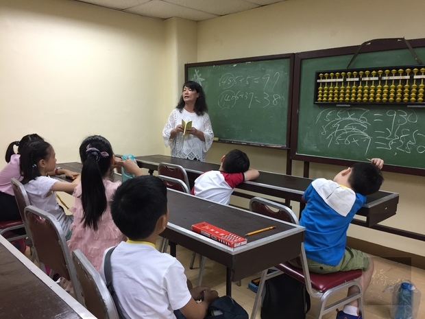 李雪瑩老師教導珠心算班學員乘除法。