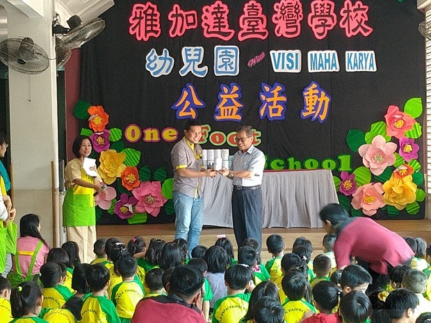 雅加達臺灣學校校長陳國樑代表(右)致贈零錢罐予MAHA KARYA殘疾協會代表(左)。