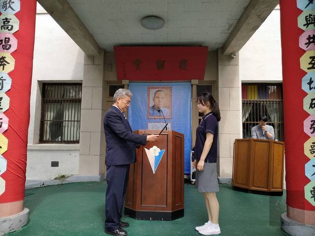 李紅連代表全體畢業生從孫承宗手中受領畢業證書。