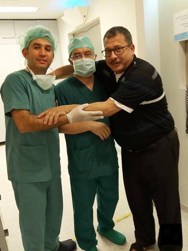 手術成功後爸爸感激地抱著醫師們並致謝。