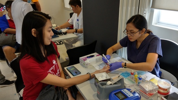 FE DEL MUNDO醫療中心醫護人員為菲華青年服務團成員測血色素。