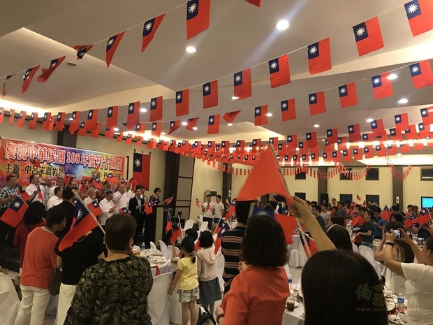 徐佩勇與僑界幹部大合唱「中華民國頌」及「梅花」，臺下賓客手持國旗開心揮舞。