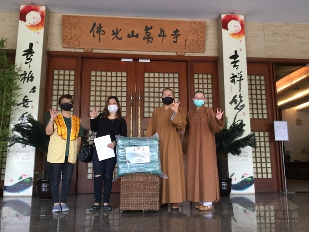 覺林法師〈右2〉與萬年寺有霖法師〈右1〉移交防護衣予受惠單位代表。