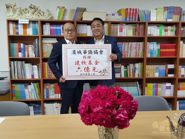 李寶禮(左)代表漢城華僑協會捐贈漢城華僑小學建校基金6億韓元，由吳學彬(右)代表接受。